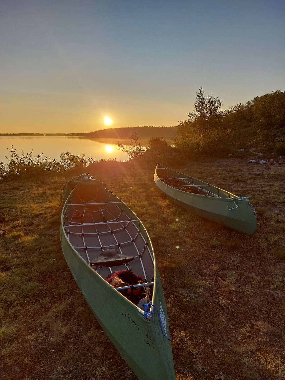 Canoe en bord de rivière au coucher du soleil