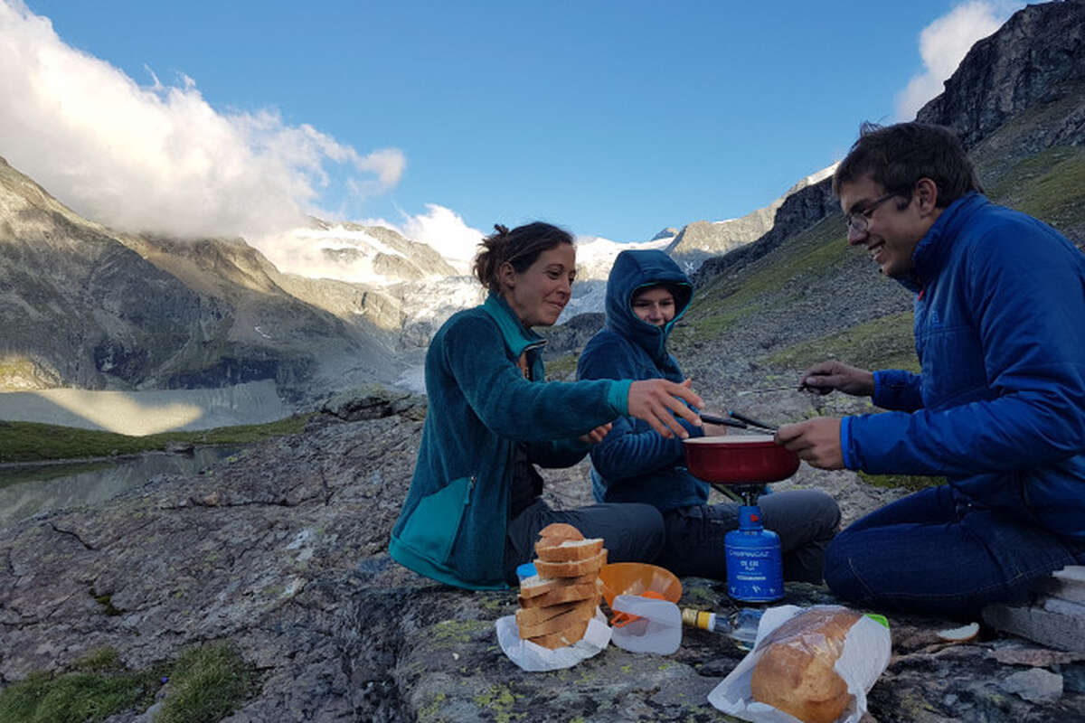 Personnes repas au réchaud devant montagnes