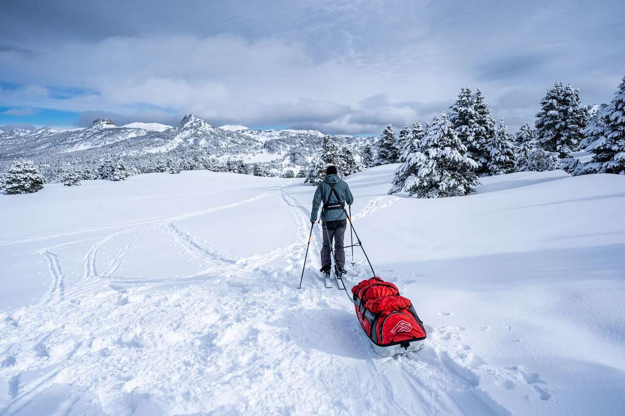 Skieur avec pulka dans la neige