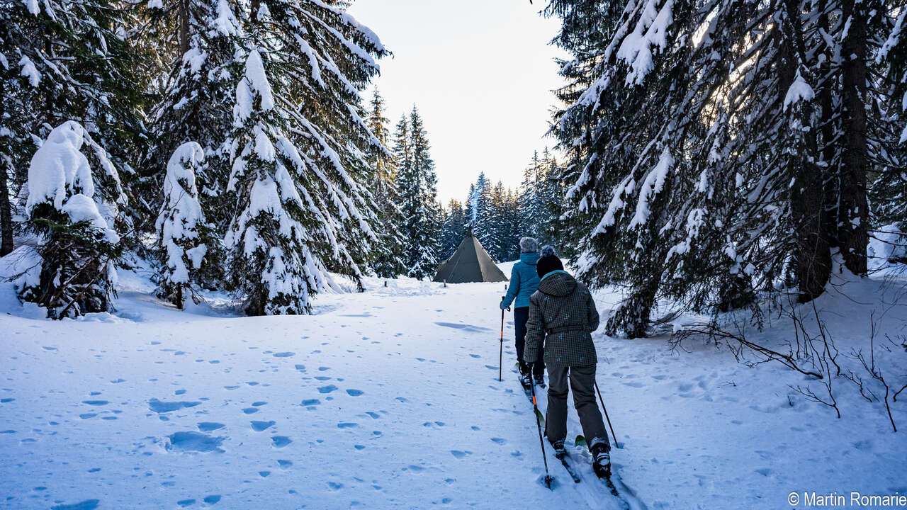 Skieur dans la forêt et tente