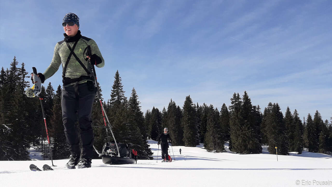 Skieur et pulka dans la neige