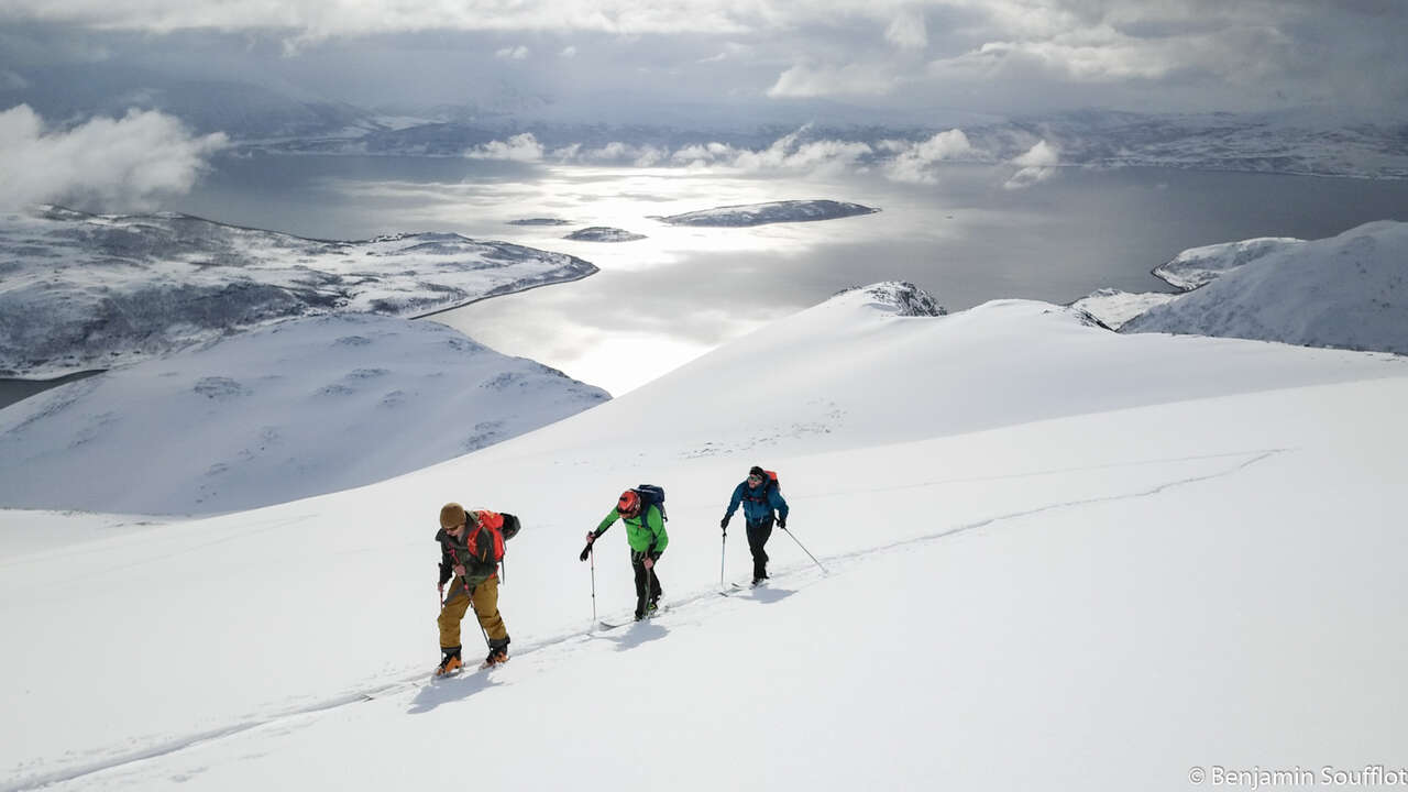 Skieurs et fjord enneigé