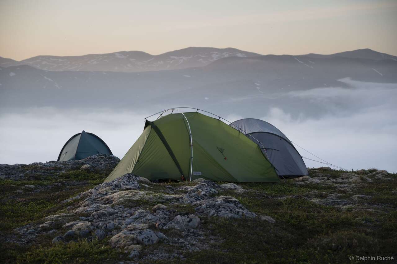 Tentes devant paysage de montagne